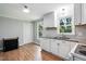 Bright kitchen featuring white cabinets, granite countertops, and wood-look flooring at 5805 Farm Gate Rd, Raleigh, NC 27606