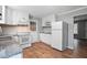Functional kitchen with white appliances, granite countertops, and wood-look flooring at 5805 Farm Gate Rd, Raleigh, NC 27606