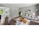 Inviting living room with neutral tones, stylish furnishings, and hardwood flooring, open to kitchen at 5805 Farm Gate Rd, Raleigh, NC 27606
