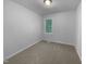 This bedroom features neutral walls and carpet, bright natural light from a window, and a minimalistic look at 6005 Antigua, Knightdale, NC 27545