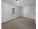Simple bedroom with plush carpet, overhead lighting, and a window overlooking the yard at 6005 Antigua, Knightdale, NC 27545