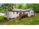 This home features a spacious backyard with a wooden deck and mature trees at 6204 Silver Spring Ct, Willow Springs, NC 27592