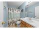 The bathroom features a shower-tub combo with a floral curtain and wood-look flooring at 6204 Silver Spring Ct, Willow Springs, NC 27592