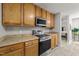 Well-lit kitchen featuring wooden cabinets, stainless steel appliances, and neutral countertops at 6204 Silver Spring Ct, Willow Springs, NC 27592