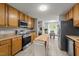 Well-equipped kitchen featuring wood cabinets, stainless appliances, and view into dining area at 6204 Silver Spring Ct, Willow Springs, NC 27592