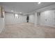 A finished basement with neutral carpet and painted support beams offers space for activities at 623 Oakgrove Dr, Graham, NC 27253