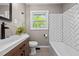 Updated bathroom featuring modern vanity, sleek black hardware, decorative mirror, and subway tile at 623 Oakgrove Dr, Graham, NC 27253