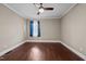 Bright bedroom with hardwood floors, a ceiling fan, and a large window with blue curtains at 623 Oakgrove Dr, Graham, NC 27253