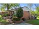 Charming brick home featuring a classic covered porch, mature trees and manicured landscaping at 623 Oakgrove Dr, Graham, NC 27253