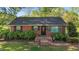 Charming brick home features a well-manicured lawn with lush shrubbery and a classic front entrance at 623 Oakgrove Dr, Graham, NC 27253