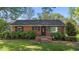 Charming single-story brick home featuring manicured landscaping and a covered front porch at 623 Oakgrove Dr, Graham, NC 27253