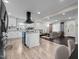 Bright, open-concept kitchen with white cabinets, a black range hood, and an island flows into a living room at 623 Oakgrove Dr, Graham, NC 27253
