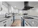 Updated kitchen boasts white cabinets, granite countertops, stainless appliances, black hardware, and modern subway tile at 623 Oakgrove Dr, Graham, NC 27253