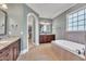 Spacious bathroom featuring a soaking tub, double vanity with granite countertops, and a walk-in closet at 628 Carolina Crossings Dr, Apex, NC 27523