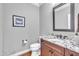 Powder room with vanity, granite countertop, framed mirror, and decorative artwork at 628 Carolina Crossings Dr, Apex, NC 27523
