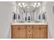 The bathroom features a double vanity with framed mirrors, light countertops and wood cabinets at 628 Carolina Crossings Dr, Apex, NC 27523