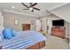 A bedroom with a dark wood bed frame, carpeted floors, and an entertainment center with a TV at 628 Carolina Crossings Dr, Apex, NC 27523