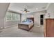 This carpeted bedroom features a dark wood bed frame, light grey walls, and a ceiling fan at 628 Carolina Crossings Dr, Apex, NC 27523