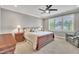 Bedroom with a ceiling fan, bedside lamps, shuttered windows, carpet flooring and a wooden bed frame at 628 Carolina Crossings Dr, Apex, NC 27523