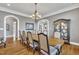 Elegant dining room features a wood table, ornate chandelier, hardwood floors, and arched doorways at 628 Carolina Crossings Dr, Apex, NC 27523