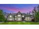 Stunning two-story brick and stone home featuring a manicured lawn and elegant architectural details at 628 Carolina Crossings Dr, Apex, NC 27523