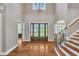 Bright foyer with hardwood floors, staircase, and arched doorway leading into another room at 628 Carolina Crossings Dr, Apex, NC 27523