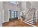 Grand foyer with hardwood floors, staircase, and views into the formal dining room at 628 Carolina Crossings Dr, Apex, NC 27523