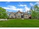 Two-story stone and brick home featuring a manicured front yard and well maintained landscaping at 628 Carolina Crossings Dr, Apex, NC 27523