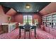 Carpeted game room with a wet bar, table, seating, and built-in shelving with movies at 628 Carolina Crossings Dr, Apex, NC 27523