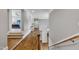 Hallway with stairs and hardwood floors leading to a bedroom with hardwood floors and a gray color scheme at 628 Carolina Crossings Dr, Apex, NC 27523