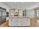 Gourmet kitchen with white cabinets, stainless steel appliances, and granite island at 628 Carolina Crossings Dr, Apex, NC 27523