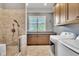 Laundry room with a wash station, tiled walk-in shower, tile flooring, natural light, and washer/dryer at 628 Carolina Crossings Dr, Apex, NC 27523