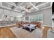 Open-concept living room featuring coffered ceilings, hardwood floors, and a bar counter to the kitchen at 628 Carolina Crossings Dr, Apex, NC 27523
