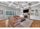 Cozy living room boasts built-in cabinets, stone fireplace and coffered ceilings with hardwood floors at 628 Carolina Crossings Dr, Apex, NC 27523