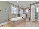 Luxurious main bathroom features a soaking tub, glass shower, and tiled flooring at 628 Carolina Crossings Dr, Apex, NC 27523