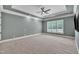 Open main bedroom features tray ceilings, neutral carpet, and large windows with view to the backyard at 628 Carolina Crossings Dr, Apex, NC 27523