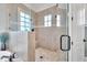 Walk-in shower with glass enclosure featuring tile walls, a built-in bench, and a window for natural light at 628 Carolina Crossings Dr, Apex, NC 27523