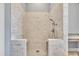 Walk-in shower with white brick surround and glass partition featuring overhead shower fixture and gray tiled floor at 628 Carolina Crossings Dr, Apex, NC 27523