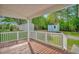 View from the back porch, looking out to two sheds and a spacious grassy yard surrounded by lush trees at 701 Oakwood St, Mebane, NC 27302