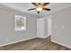This bedroom features a ceiling fan, natural light from the window, neutral walls and vinyl plank flooring at 701 Oakwood St, Mebane, NC 27302