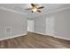 Large bedroom with ceiling fan, grey walls, white trim, and luxury vinyl plank flooring at 701 Oakwood St, Mebane, NC 27302