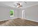 Neutral bedroom with ceiling fan, grey walls, white trim, and luxury vinyl plank flooring at 701 Oakwood St, Mebane, NC 27302