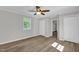 Light-filled bedroom featuring neutral paint, white trim, ceiling fan and vinyl plank flooring at 701 Oakwood St, Mebane, NC 27302