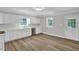 Bright kitchen features white cabinets, stainless steel dishwasher, and luxury vinyl plank flooring at 701 Oakwood St, Mebane, NC 27302