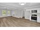 Open-concept living and kitchen area with stainless appliances and bright, natural light at 701 Oakwood St, Mebane, NC 27302