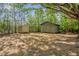 Two outbuildings situated on a grassy lot shaded by mature trees, providing ample outdoor storage space at 701 Oakwood St, Mebane, NC 27302