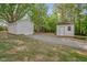 Two sheds with a gravel path sit on a grassy lot surrounded by trees at 701 Oakwood St, Mebane, NC 27302