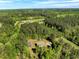 Expansive aerial view showcasing the home nestled among lush greenery and surrounding wooded areas at 7030 Shep Royster Rd, Oxford, NC 27565
