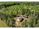 Aerial view of a home featuring a detached garage, lush trees, and a private, natural landscape at 7030 Shep Royster Rd, Oxford, NC 27565