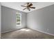 Cozy bedroom with a ceiling fan, plush carpeting, and natural light streaming through the window at 7030 Shep Royster Rd, Oxford, NC 27565
